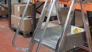 Escabeau sécurisé pour travail en hauteur dans un entrepôt de stockage.